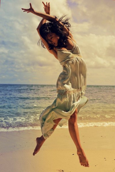 Девушка танцует у моря