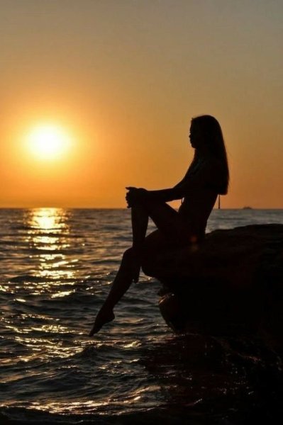 Девочка сидит на берегу моря