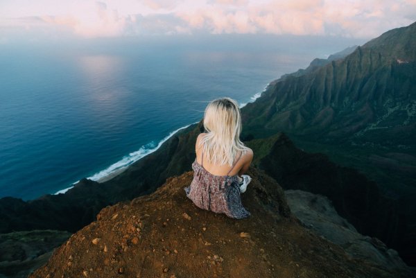 Блондинка на скале спиной