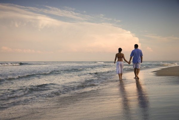 Влюбленные идут по берегу моря