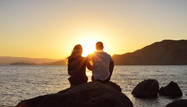 Пара на берегу на закате