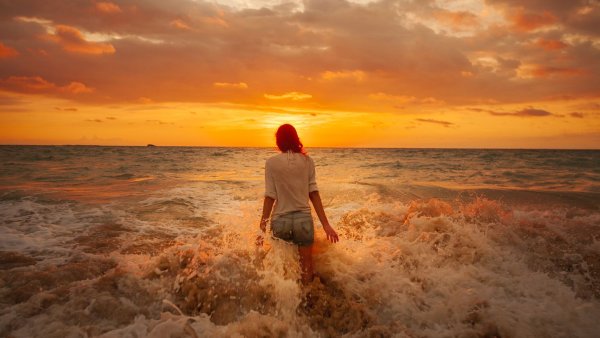 Женщина на закате у моря