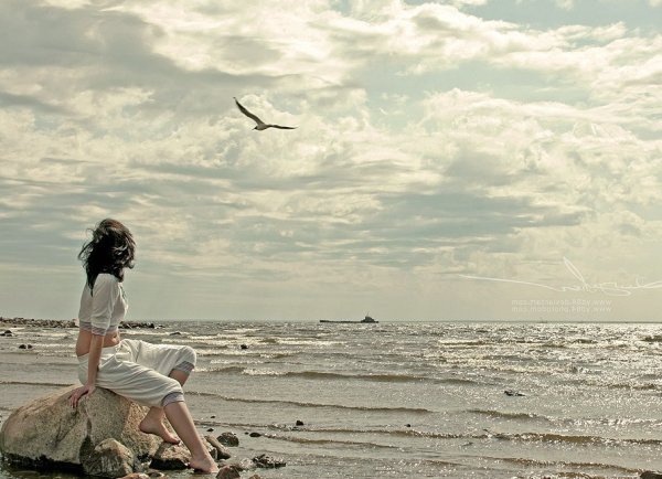 Девушка у моря задумалась