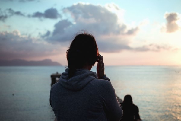 Девушка сидит на берегу спиной