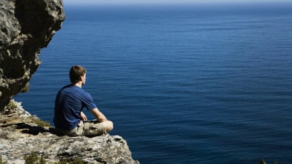 Вид сидящей девушки у моря