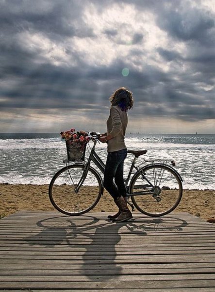 Девушка на велосипеде на море