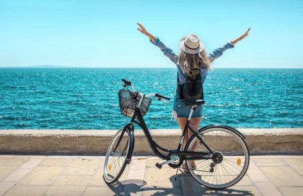 Девушка на велосипеде на набережной