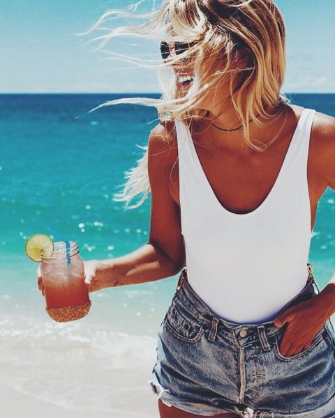 Девушка с коктейлем на пляже