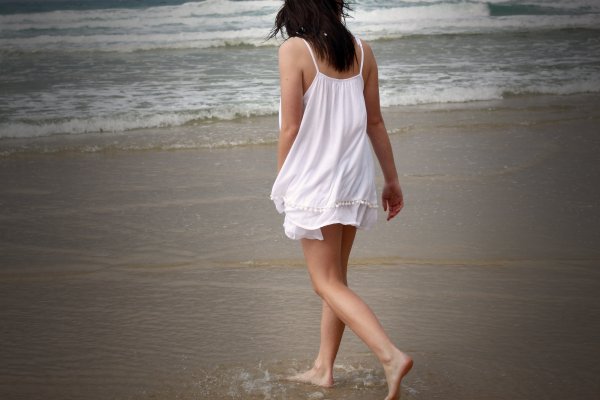 Девушка на пляже спиной в платье
