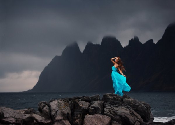 Девушка на скале у моря