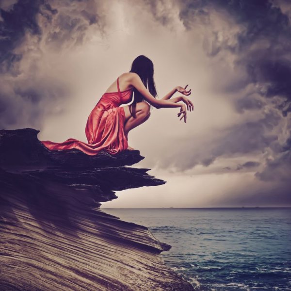 Девушка на скале у моря