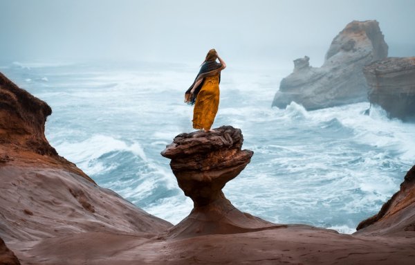 Девушка на скале у моря