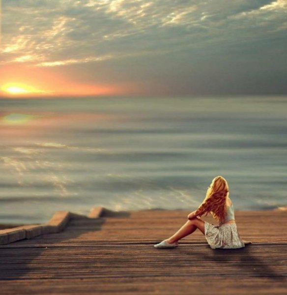 Девушка сидит у моря