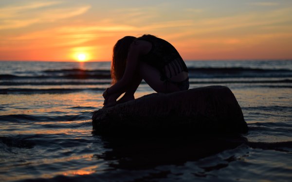 Девушка сидит у моря