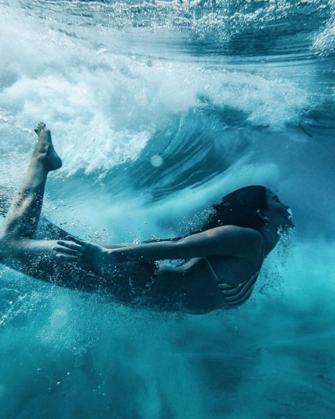 Девушка ныряет в море