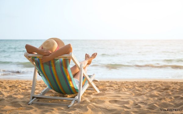 Человек в шезлонге на пляже