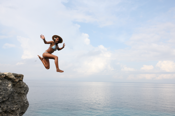 Девушка прыгает в море