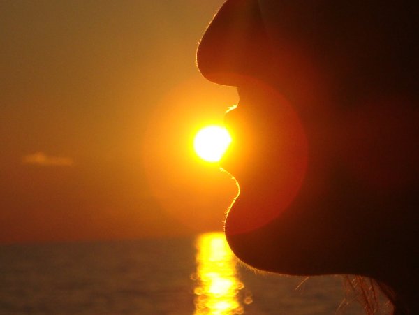 Девушка целует солнце