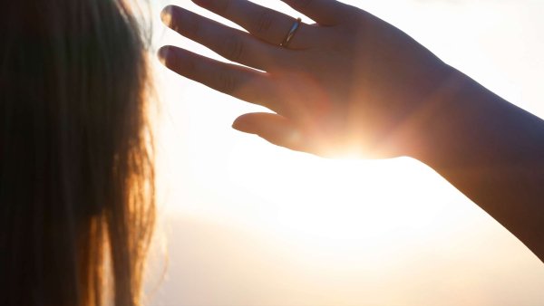 Прикрывает лицо от солнца