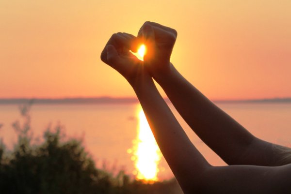 Солнце в сердечке из рук