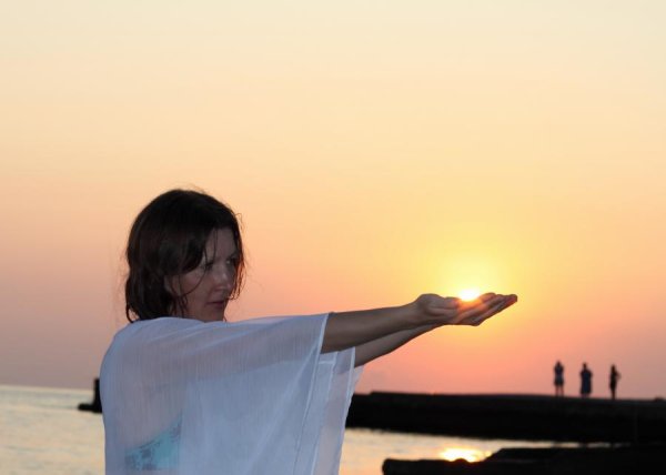 Девушка держит солнце в руках