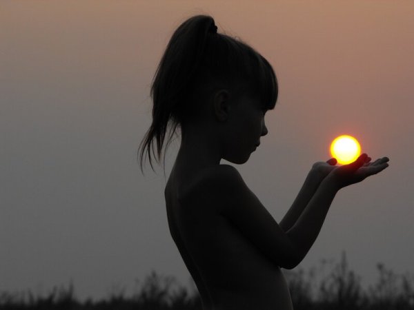 Девушка держит солнце