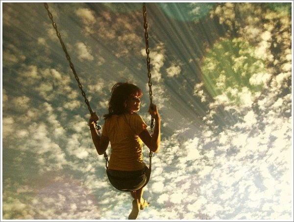 Девочка качается на качелях