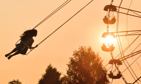 Девочка катается на качелях