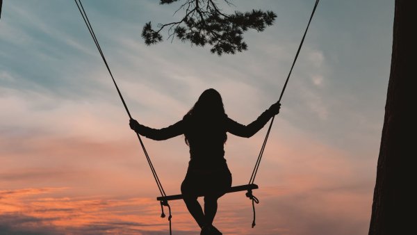 Девочка качается на качелях