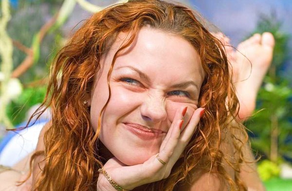 Девушка жмурится на солнце