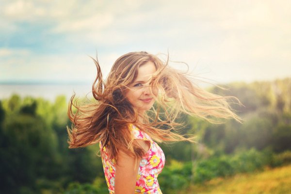 Девушка улыбается солнцу