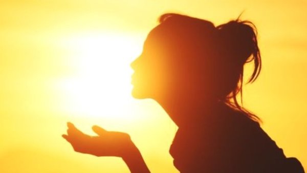 Девушка целует солнце на закате