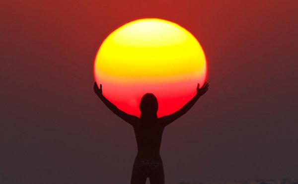 Человек держит солнце