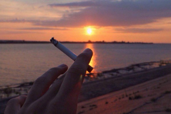 Девушка курит на закате