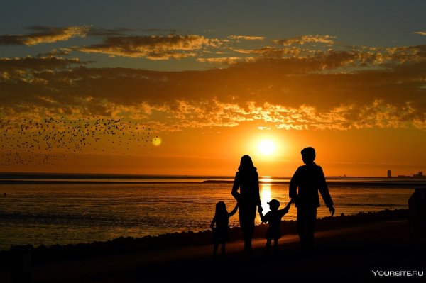 Семья на пляже закат