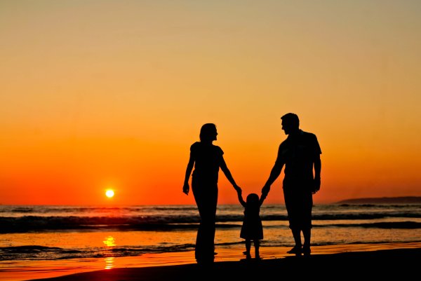 Семья с детьми на закате у моря