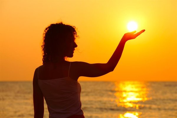 Девушка держит солнце