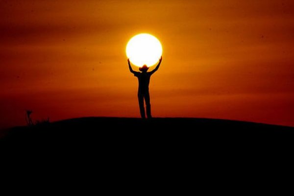 Человек держит солнце