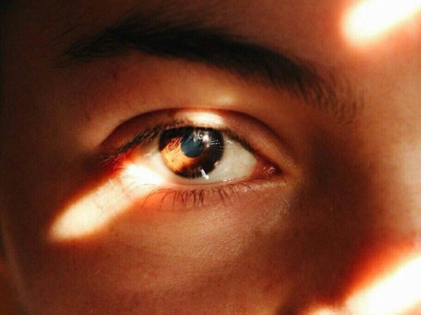 Закрывается рукой от солнца