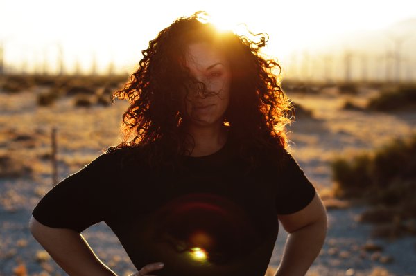 Девушка с волнистыми волосами на закате