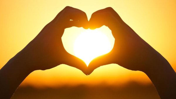 Солнце в сердечке из рук