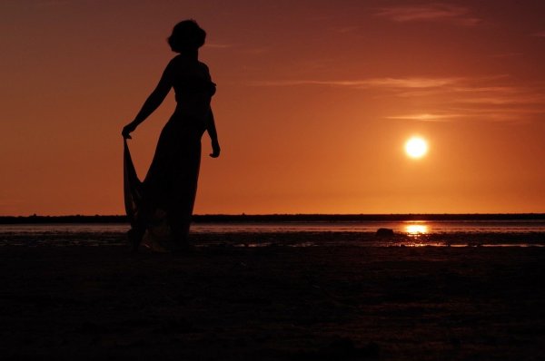 Девушка сидит на закате