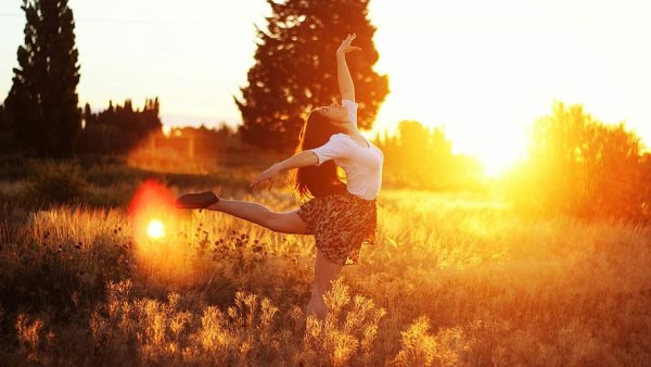 Женщина танцует в солнечных лучах