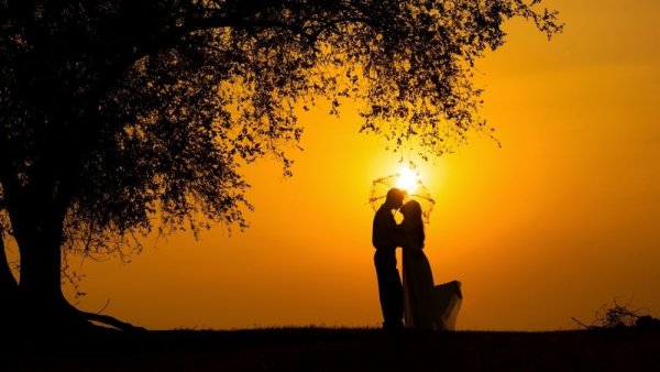 Двое на берегу моря на закате