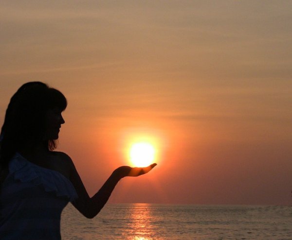 Девушка держит солнце в руках