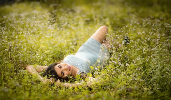 Девушка в траве со спины