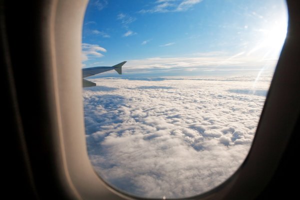 Облака в иллюминаторе самолета