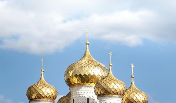 Церкви с золотыми куполами на фоне синего неба