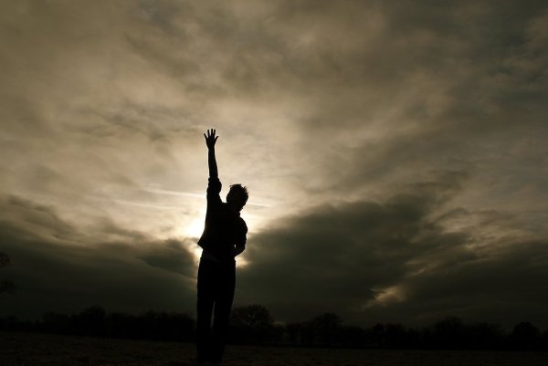 Человек тянет руку к небу