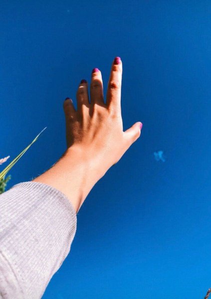 Женская рука тянется к небу